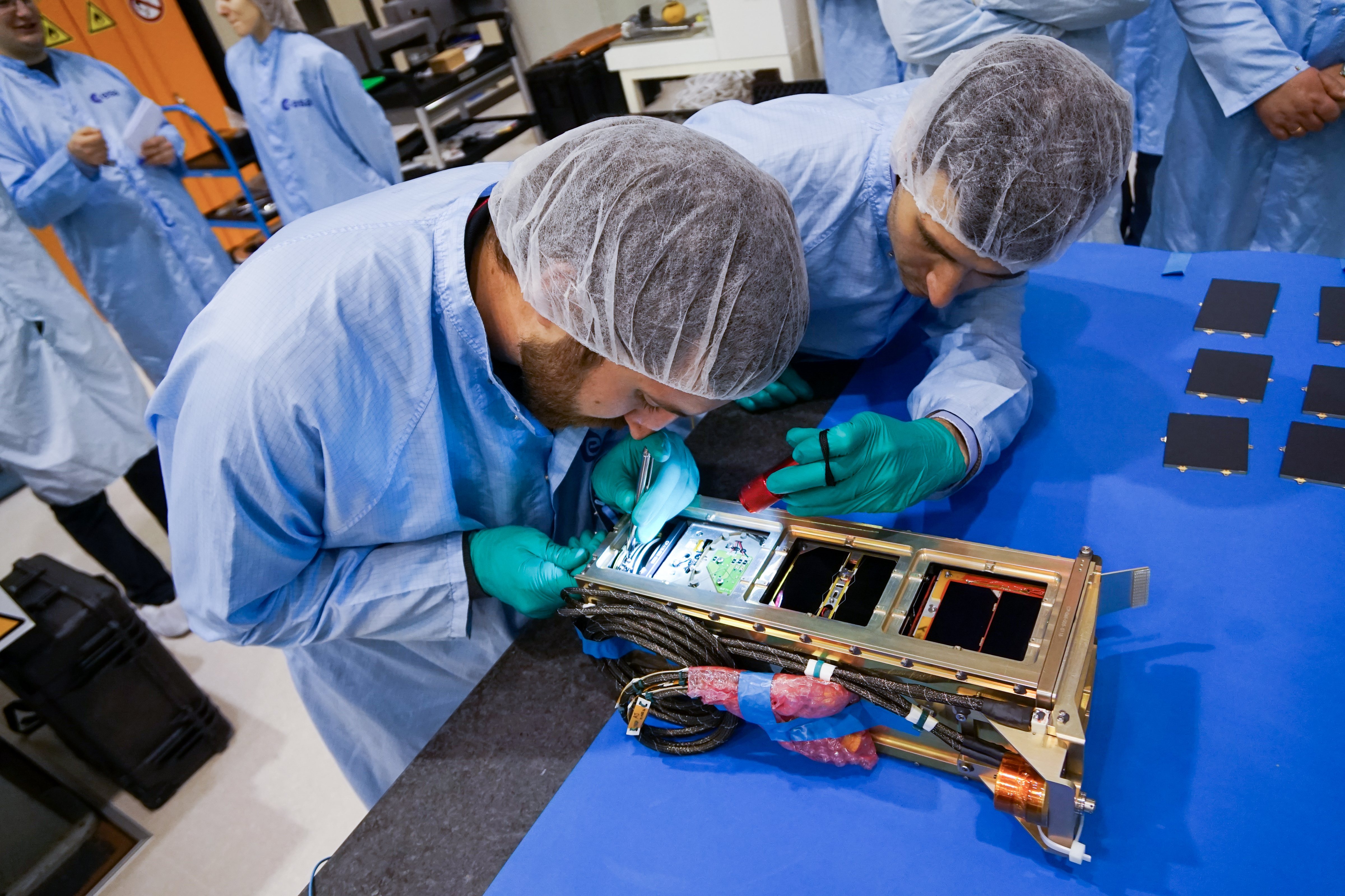 Students integrating CubeSats into orbital deployer